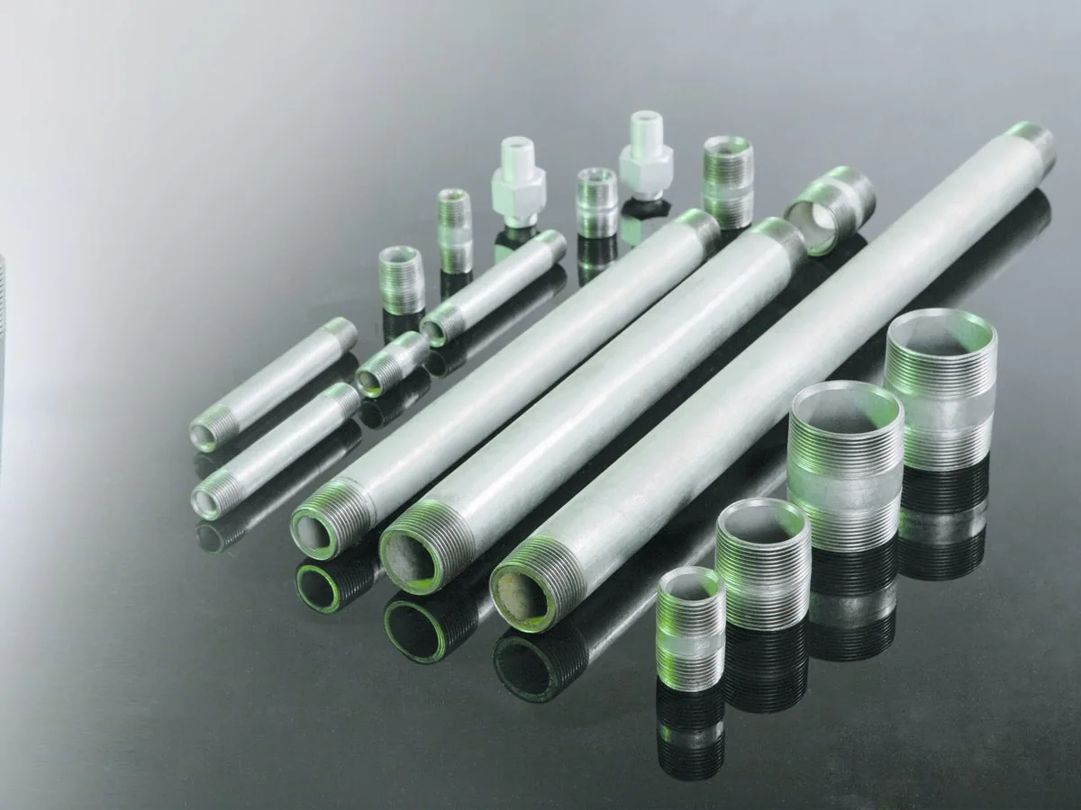 Galvanized rolled-thread pipe nipples and long pipes laid out across the size range